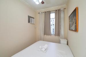 1 dormitorio con cama blanca y ventana en Rio Spot Sara 1118, en Río de Janeiro