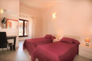 ローマにあるSan Pietro's Home - Guesthouseのベッドルーム1室(ベッド2台、デスク、テーブル付)