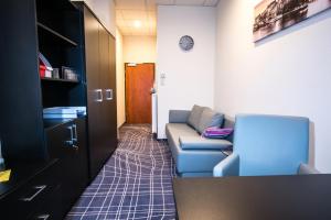 a living room with a blue couch in a room at Sky Business Hotel in Legnica