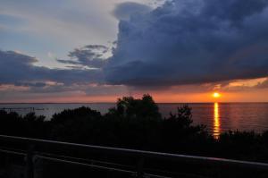 a sunset over the water with the sun setting at Promenada28pl - Apartamenty z widokiem na morze in Międzyzdroje +53 photos