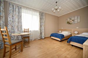 1 dormitorio con 2 camas, mesa y ventana en Hotel SRGK VOS, en Moscú