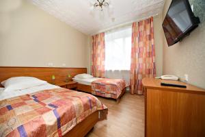 Habitación de hotel con 2 camas y TV de pantalla plana. en Hotel SRGK VOS, en Moscú