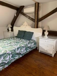 een slaapkamer met een bed en twee nachtkastjes bij DOMAINE LE CLOS in Jupilles