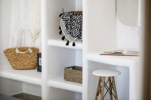 a white closet with white shelves and a stool at Naxos Earth Suites in Mikri Vigla