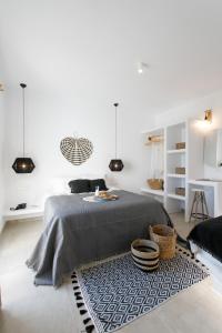 a white bedroom with a bed and a rug at Naxos Earth Suites in Mikri Vigla