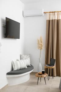 a living room with a couch and a tv at Naxos Earth Suites in Mikri Vigla