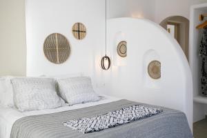 a bedroom with a bed with a white wall at Naxos Earth Suites in Mikri Vigla