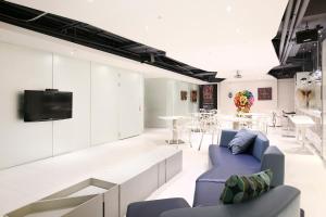 a living room with a blue couch and a tv at CityInn Hotel Plus - Ximending Branch in Taipei