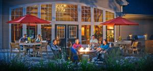 un grupo de personas sentadas en mesas en un patio en Green Mountain Suites Hotel, en Burlington