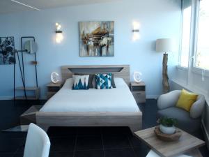 a bedroom with a large bed and a couch at Bleu Mer Duplex & Suites in Saint-Cyprien