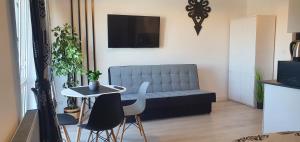 a living room with a couch and a table and chairs at Apartament u krysi in Ząb