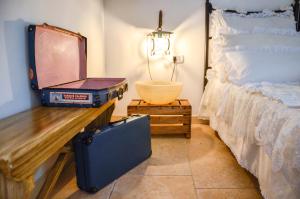 a bedroom with a bed and a suitcase and a table at Cortebbianca in Fasano