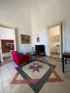 a living room with a red couch and a rug at Casa Proserpina in Catania