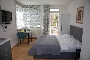 a bedroom with a bed and a table and a window at Apartmán u Doktora in Banská Bystrica