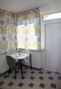 einen Tisch und einen Stuhl in einem Zimmer mit einer Tür in der Unterkunft Apartmán u Doktora in Banská Bystrica