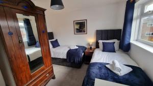 - une petite chambre avec 2 lits et un miroir dans l'établissement Stockwood House by Cliftonvalley Apartments, à Bristol