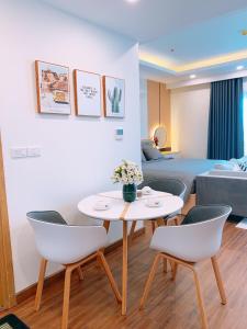 クイニョンにあるFLC Sea Tower Quy Nhon - Seaview Apartelのテーブルと椅子とベッドのあるリビングルーム