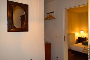 a bedroom with a mirror on the wall and a bed at Oranje City Hotel in Diest