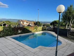 a swimming pool in a yard with a street light at Casa Cuesta del Reloj in Piedralaves
