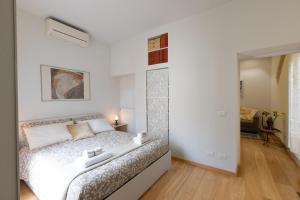 a white bedroom with a bed in a room at Trevi Rome Central House in Rome