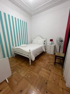 リスボンにあるClassy and cozy Double room in Marques de Pombal, Nautic, with shared Bathroomのウッドフロアのベッドルーム1室(白いベッド1台付)