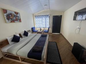 um quarto com uma cama grande e almofadas azuis em Shalom Backpackers Dharamkot McLeodganj em McLeod Ganj