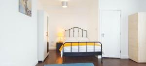 una camera con un letto in una stanza con pareti bianche di Acacia Flat 189 in Wembley a Londra
