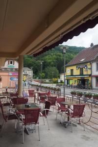 un patio al aire libre con mesas, sillas y edificios en HOTEL DES VOYAGEURS en Pont-de-Roide