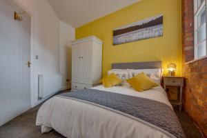 a bedroom with a large bed with yellow walls at Lovely Central 1 Bed Apartment Sleeps 4 in Sheffield