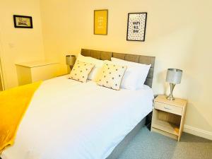 a bedroom with a large white bed with two pillows at Ilkley Apartment with Parking in Ilkley