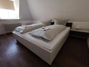 a large white bed with two pillows on it at City Hotel Franziska in Straubing