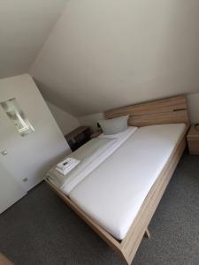 Cette petite chambre comprend un grand lit blanc. dans l'établissement City Hotel Franziska, à Straubing