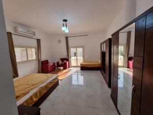 Abû Zeiraにあるفيلا العيلة Villa L-3eelaのベッドルーム1室(ベッド1台付)、リビングルームが備わります。