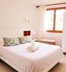 uma cama branca num quarto com uma janela em Rambla - Palma center em Palma de Maiorca