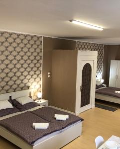 Postel nebo postele na pokoji v ubytování Árkád Apartmanház Szeged