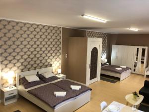 Postel nebo postele na pokoji v ubytování Árkád Apartmanház Szeged