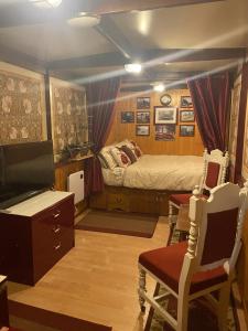 a bedroom with a bed and a tv and chairs at Rare 1954 Renovated Vintage Lorry - Costal Location in Plymouth