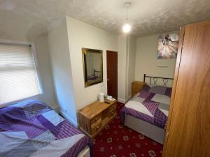 a hotel room with two beds and a mirror at The Roman Hotel in Blackpool