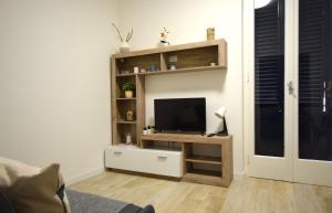 sala de estar con TV en un soporte de madera en Appartamento Tre Api, en Procchio
