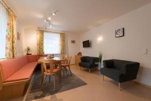 a living room with a couch and a table and chairs at Haus Walser in Sankt Anton am Arlberg