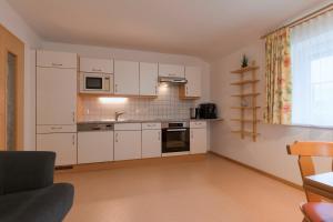 a small kitchen with white cabinets and a window at Haus Walser in Sankt Anton am Arlberg