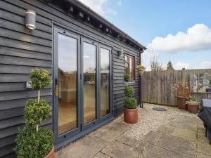 a garden room with sliding glass doors on a house at Beulah Cottage Annexe in Ashford