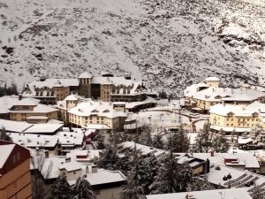 APARTAMENTO FAMILIAR Sierra DELUXE في سييرا نيفادا: مدينه مغطاه بالثلج امام جبل