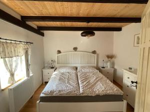 a bedroom with a large bed with a wooden ceiling at Roubenka 1818 in Všelibice