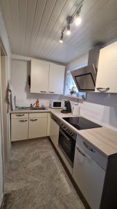 a kitchen with white cabinets and a stove top oven at Ferienwohnung Thore in Emden
