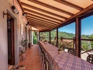 um alpendre com uma mesa longa com cadeiras e janelas em Amoliv em Arezzo