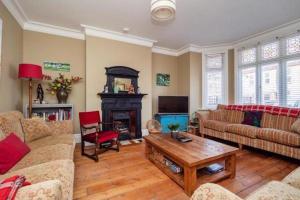 a living room with a couch and a fireplace at Seaview Villa - Norfolk Cottage Agency in Sheringham