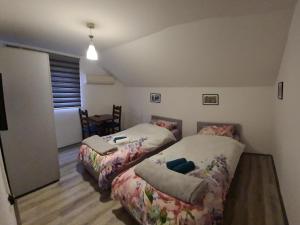 a bedroom with two beds and a table in it at Hostel FM in Mostar