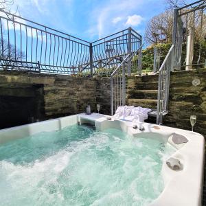 a jacuzzi tub in a building with a staircase at Ta Mill Cottages & Lodges - Smithy Cottage in Launceston