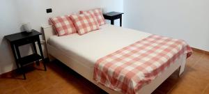 een bed met een geruite deken en twee nachtkastjes bij Comfy Apartment with WiFi and Free Parking in Arguineguín